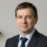 Портрет уверенного российского бизнесмена с дружелюбным взглядом на нейтральном размытом фоне в студии